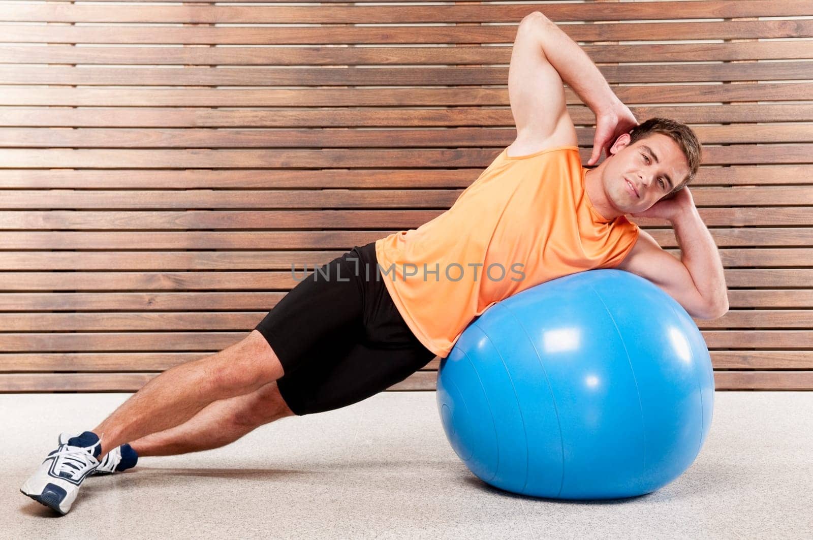 Man exercising on a fitness ball in a gym
