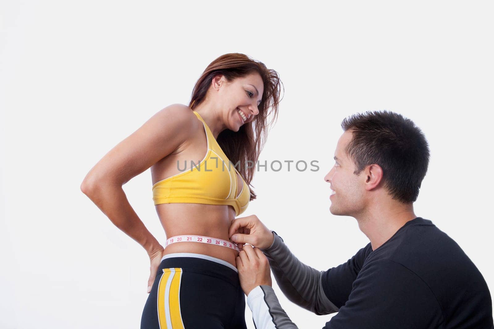Man measuring the waist of a woman with a tape measure