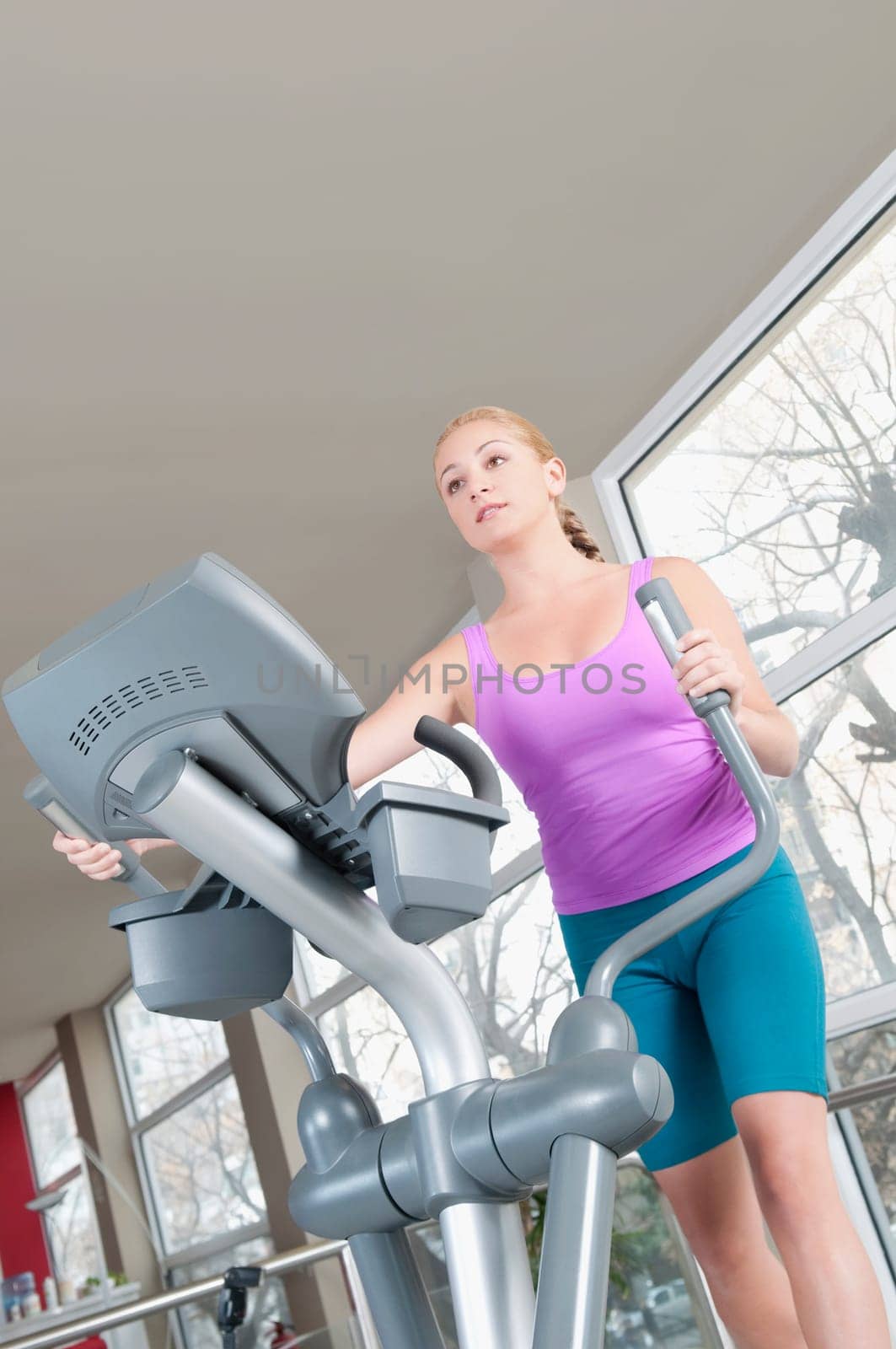 Woman working out on a stepping machine in a gym