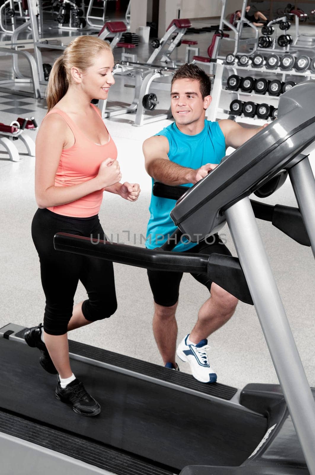 Man assisting a woman on a treadmill