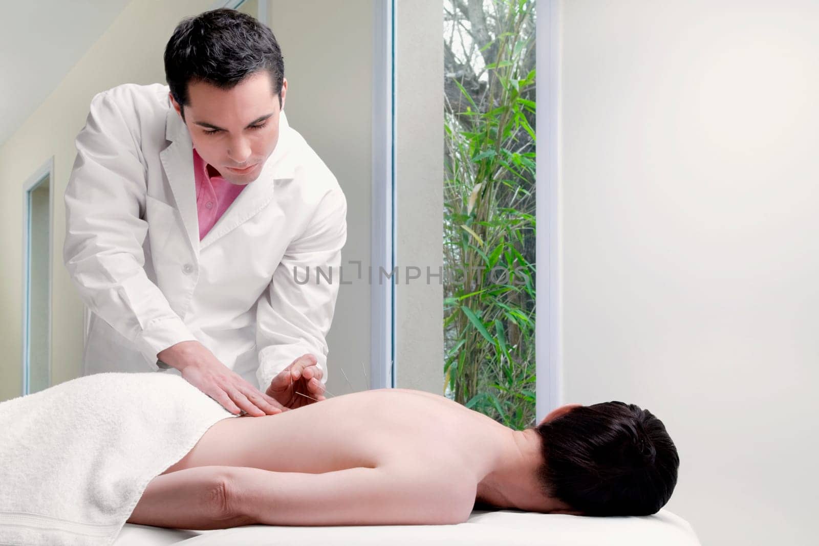 Acupuncturist applying needles on a personŽs back