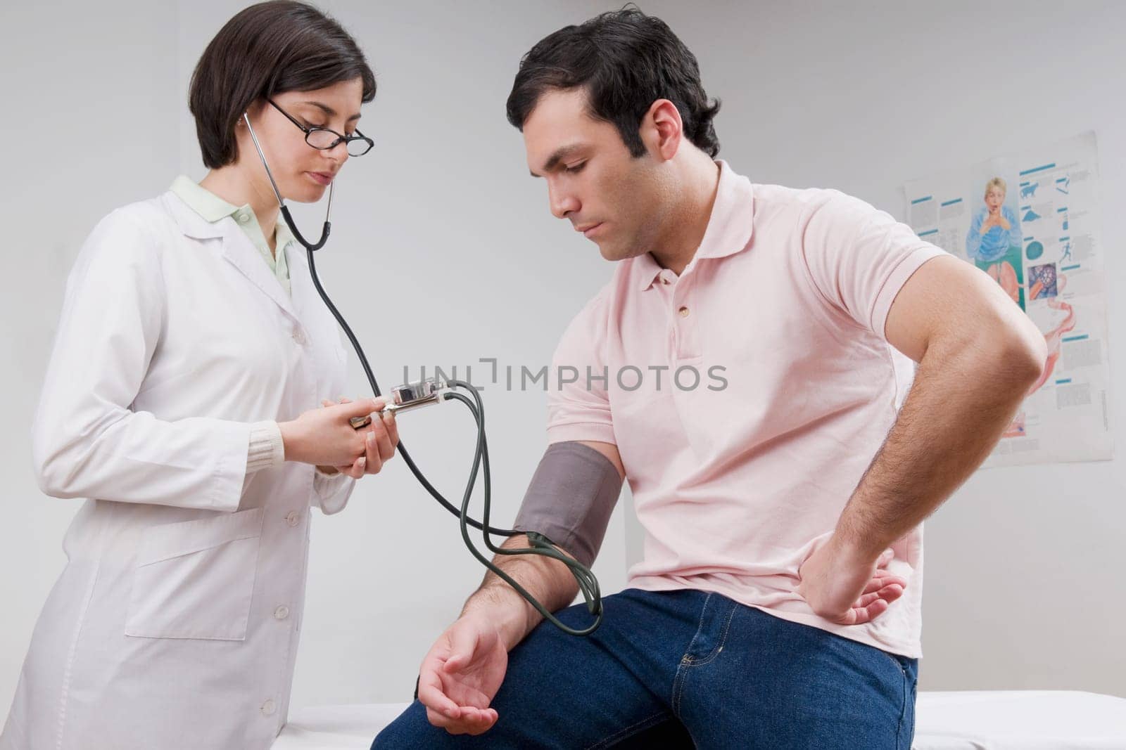 Female doctor checking manŽs blood pressure