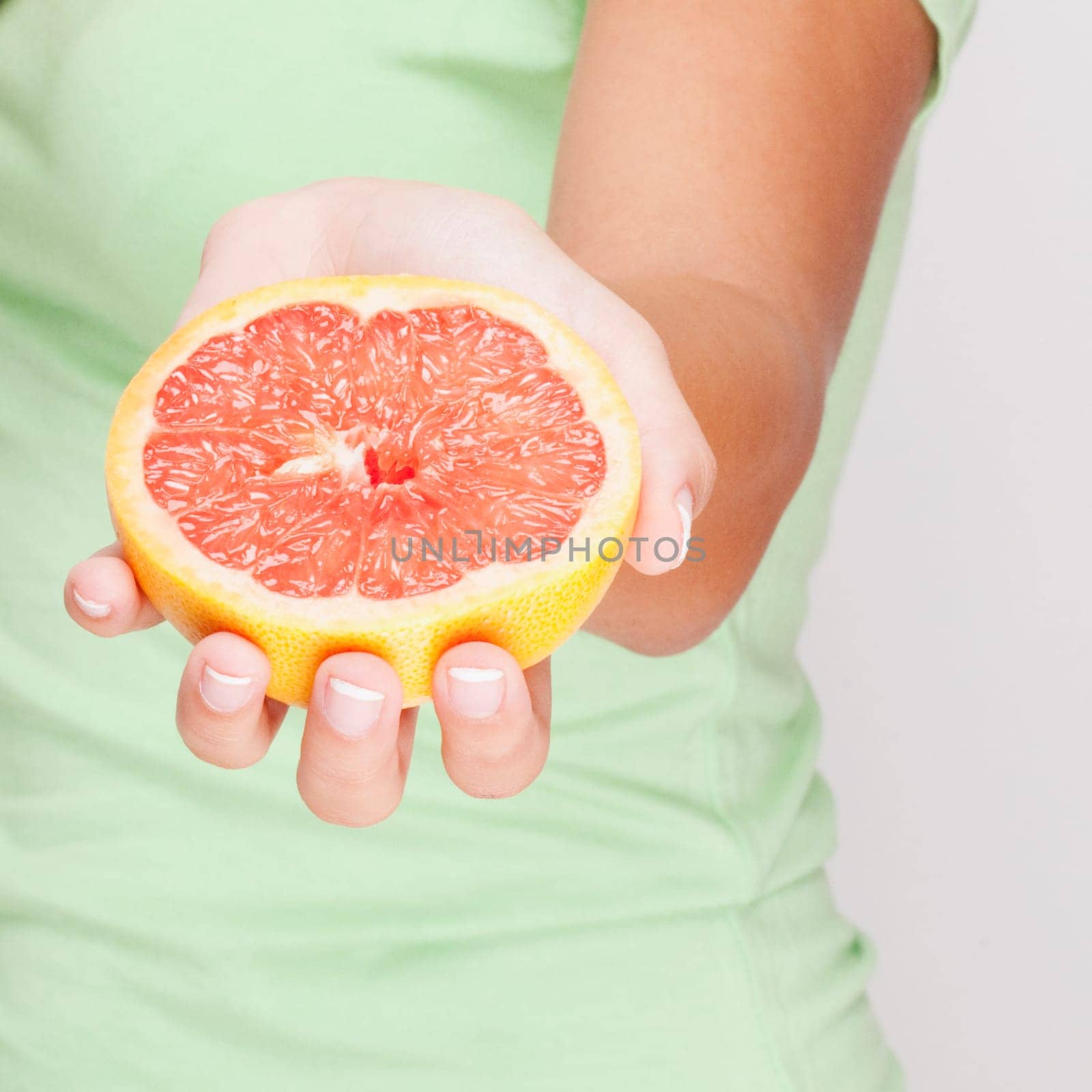 Close_up of a woman holding a grapefruit