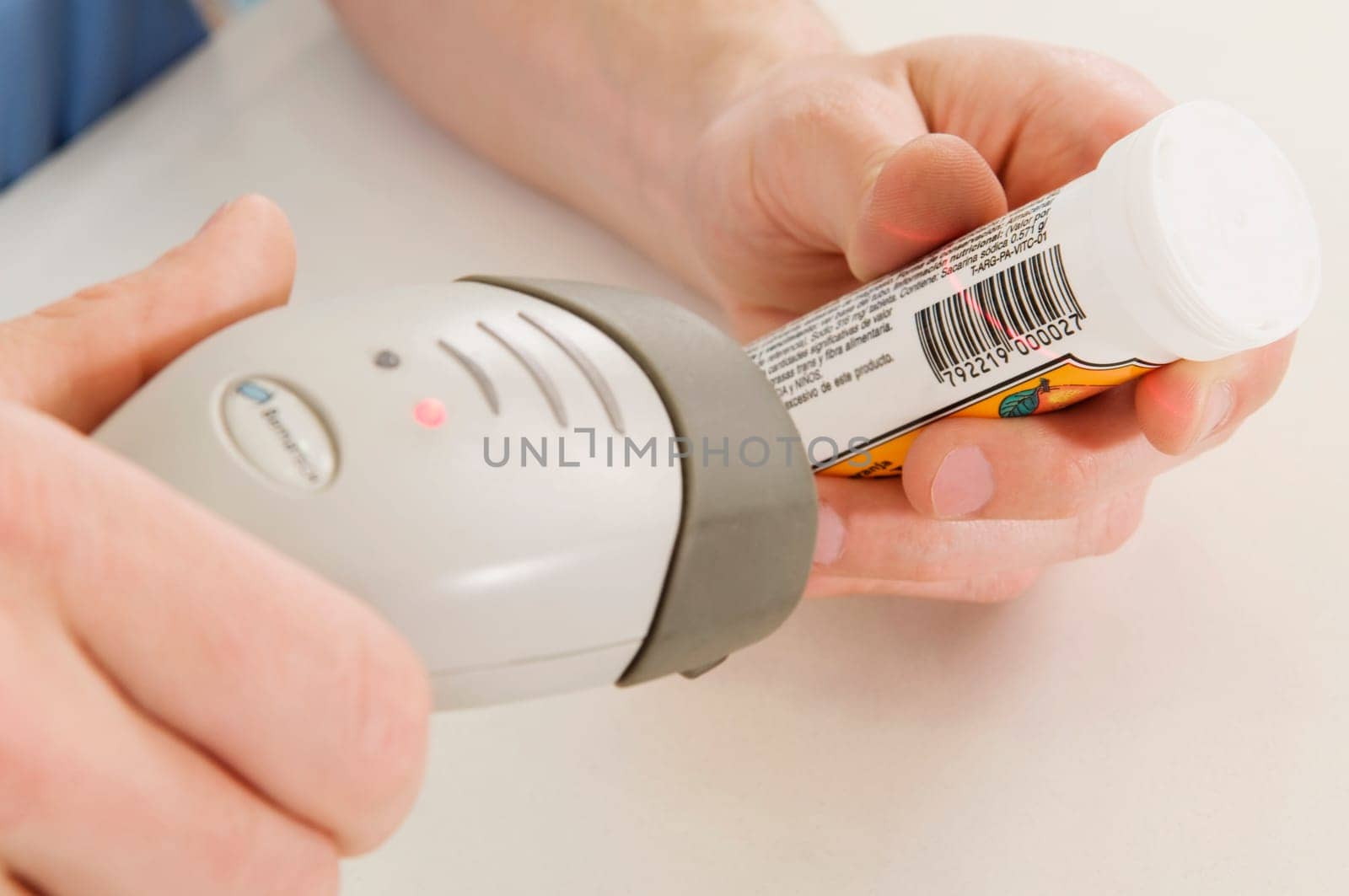 Sales clerk scanning the bottle price with a bar code reader