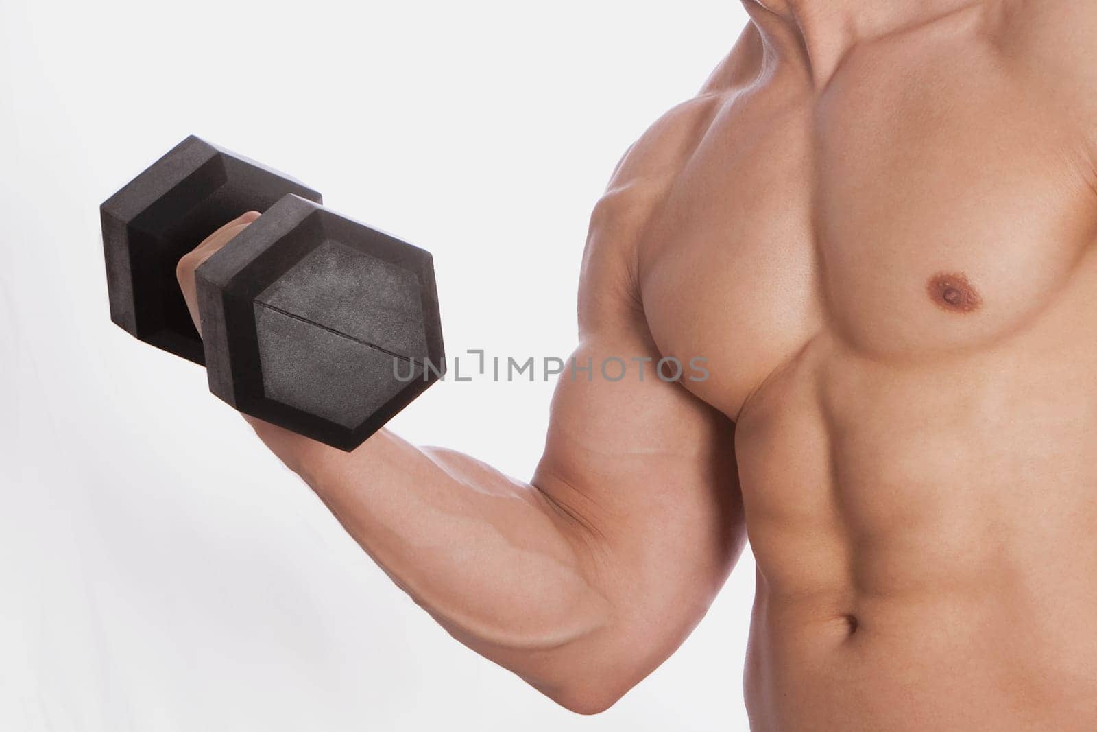 Mid section view of a man exercising with a dumbbell