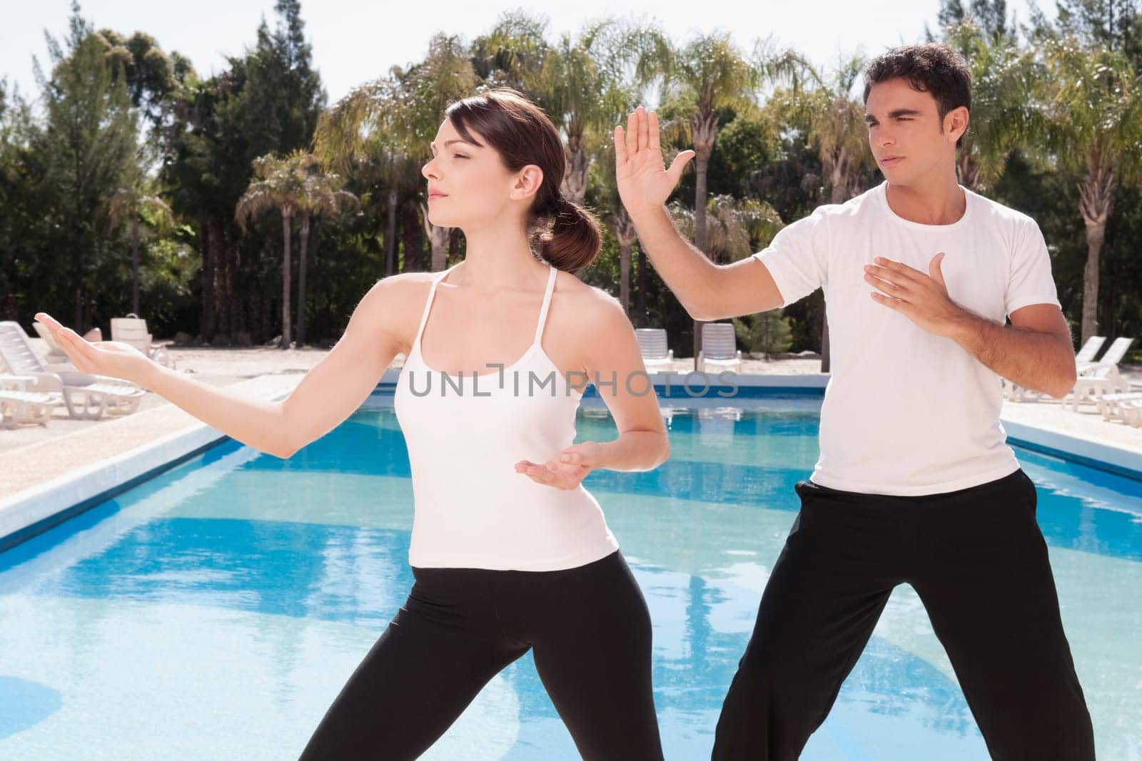 Couple exercising at the poolside
