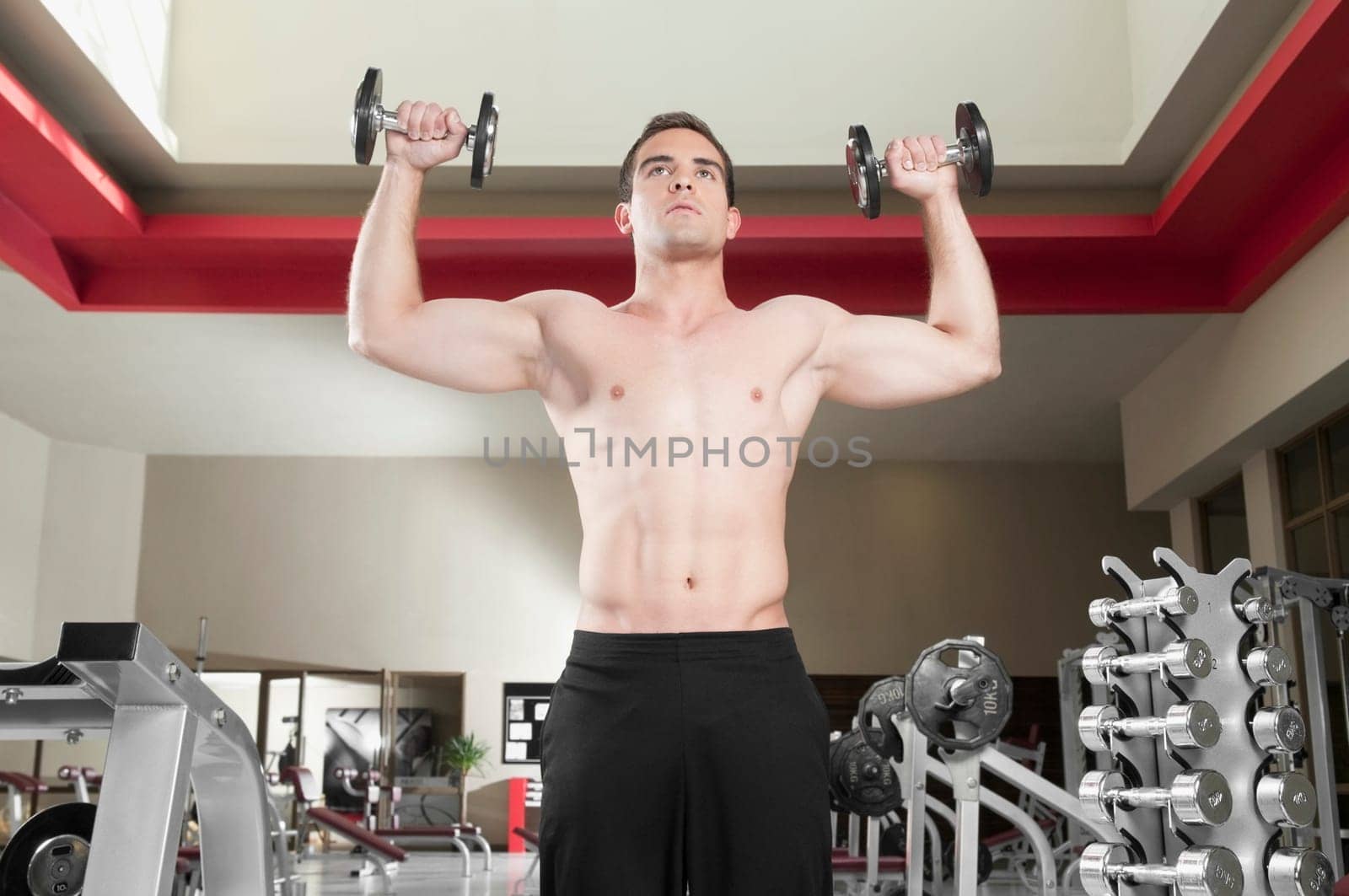 Man exercising with dumbbells in a gym