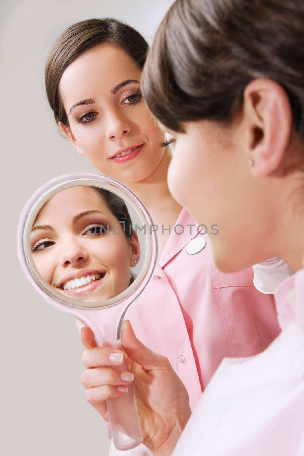Woman looking into a mirror in dentistŽs office