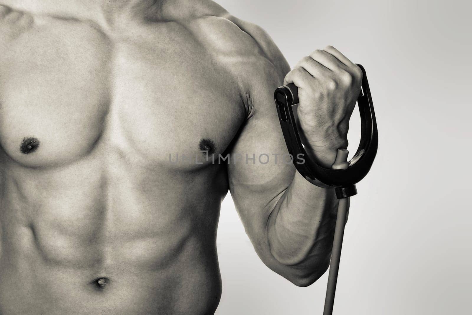 Mid section view of a man exercising with resistance band
