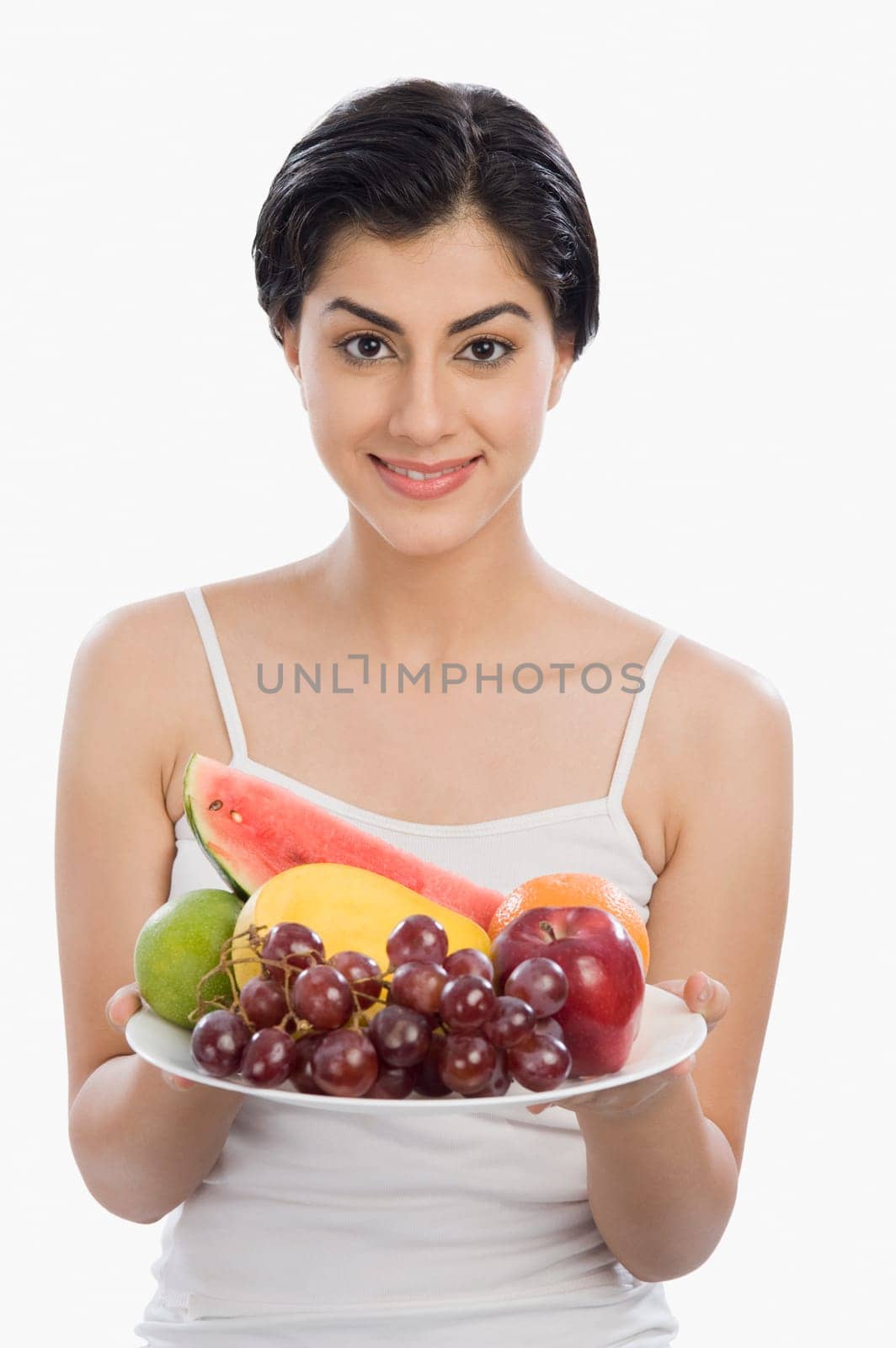 Portrait of a woman holding a plate of assorted fruits