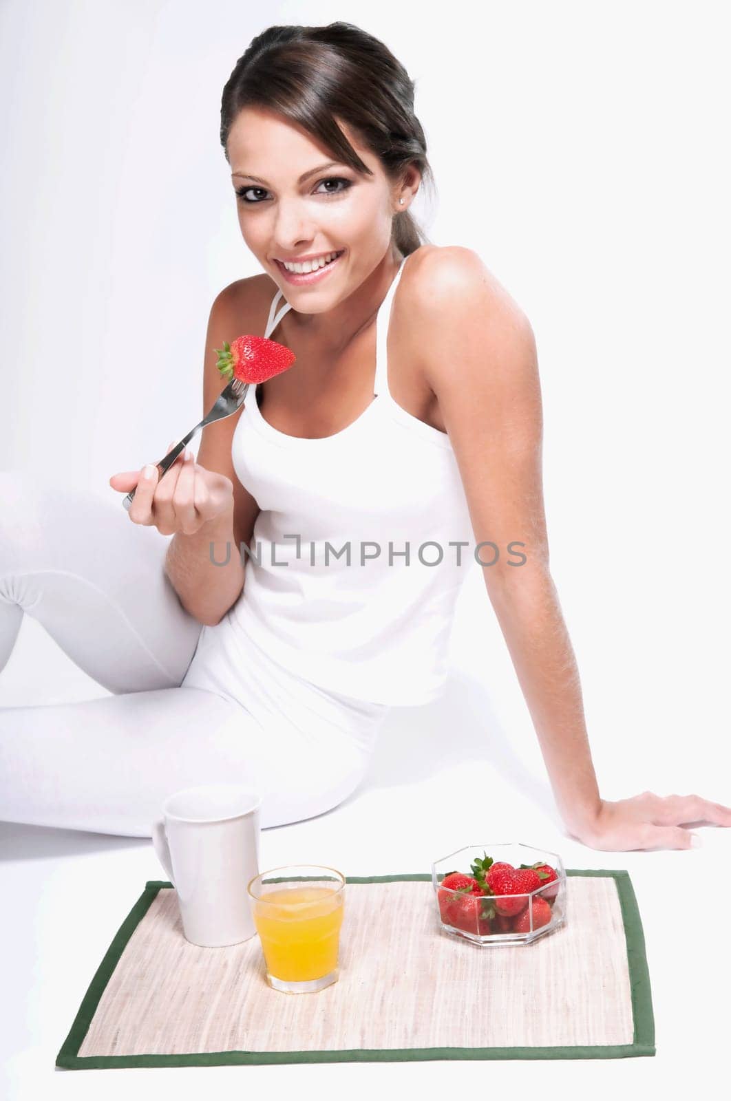 Woman sitting on the floor and eating strawberries