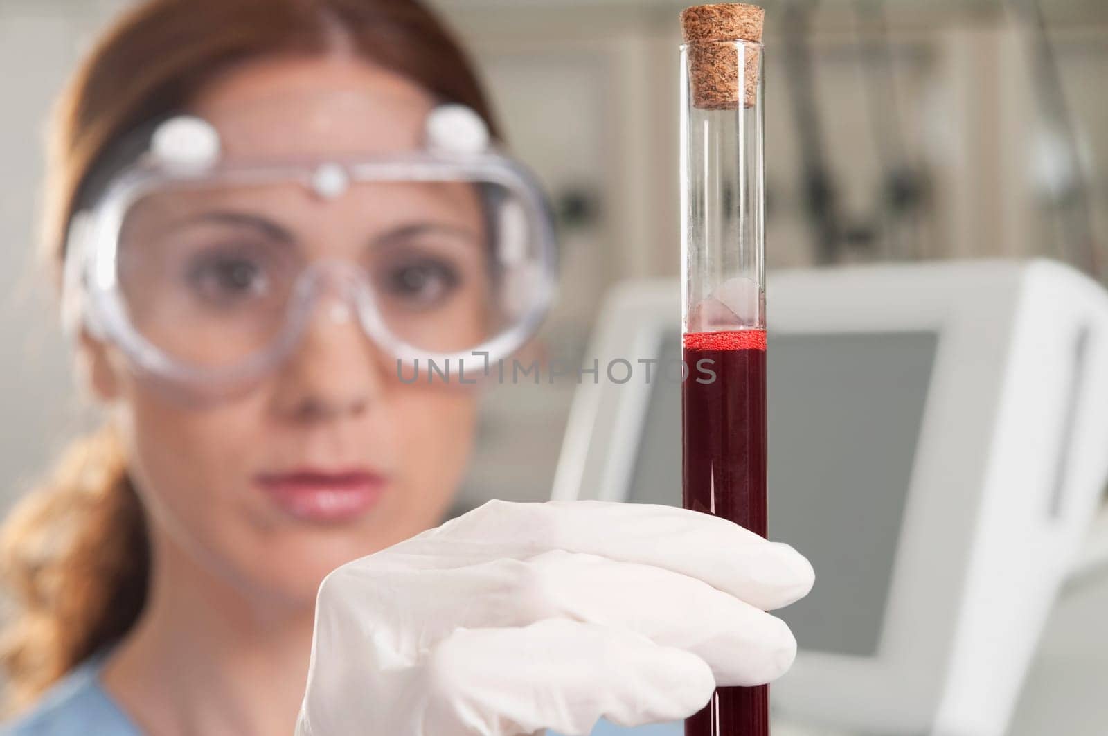 Female lab technician analyzing a blood sample in a test tube