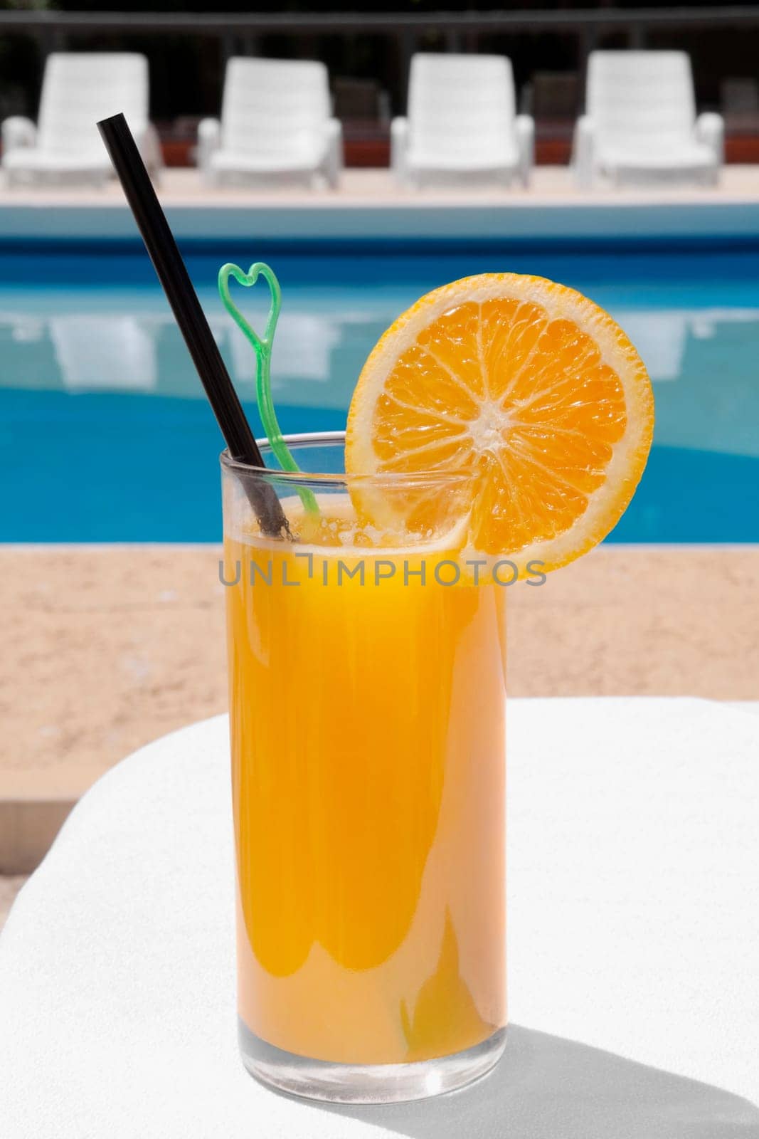 Glass of orange juice at the poolside