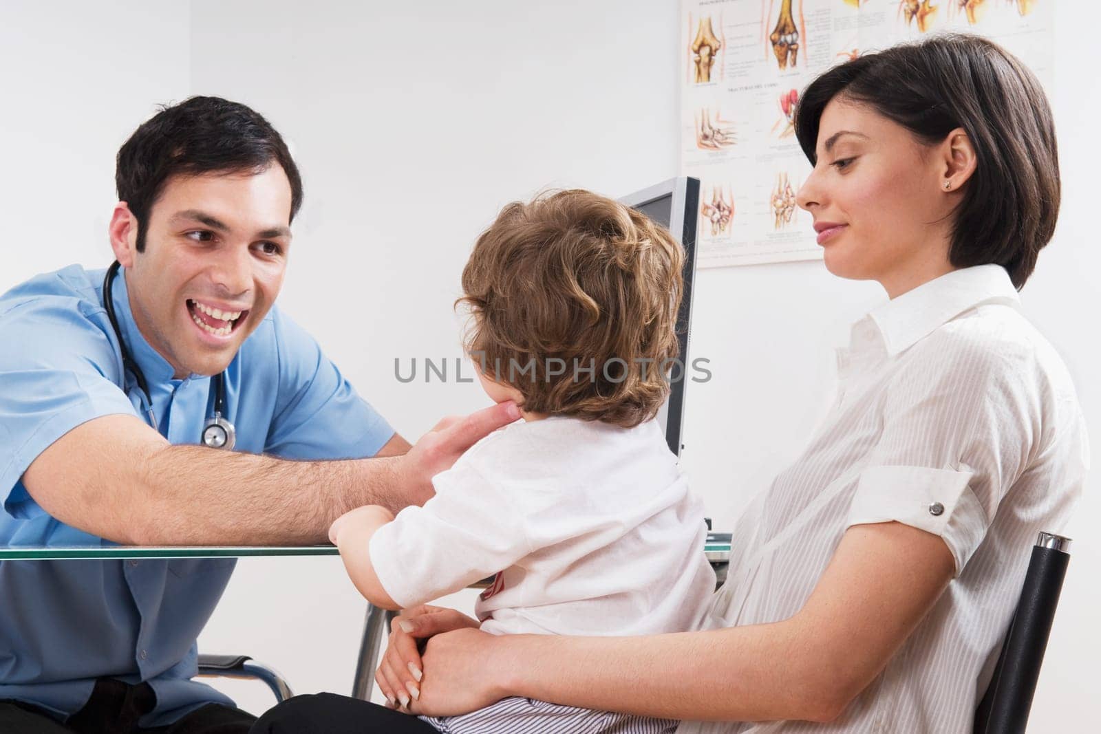 Doctor examining a baby boy sitting on his motherŽs lap
