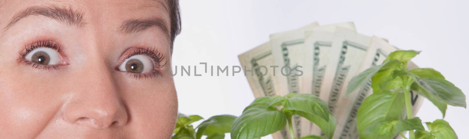 Woman looking shocked with money growing on a plant