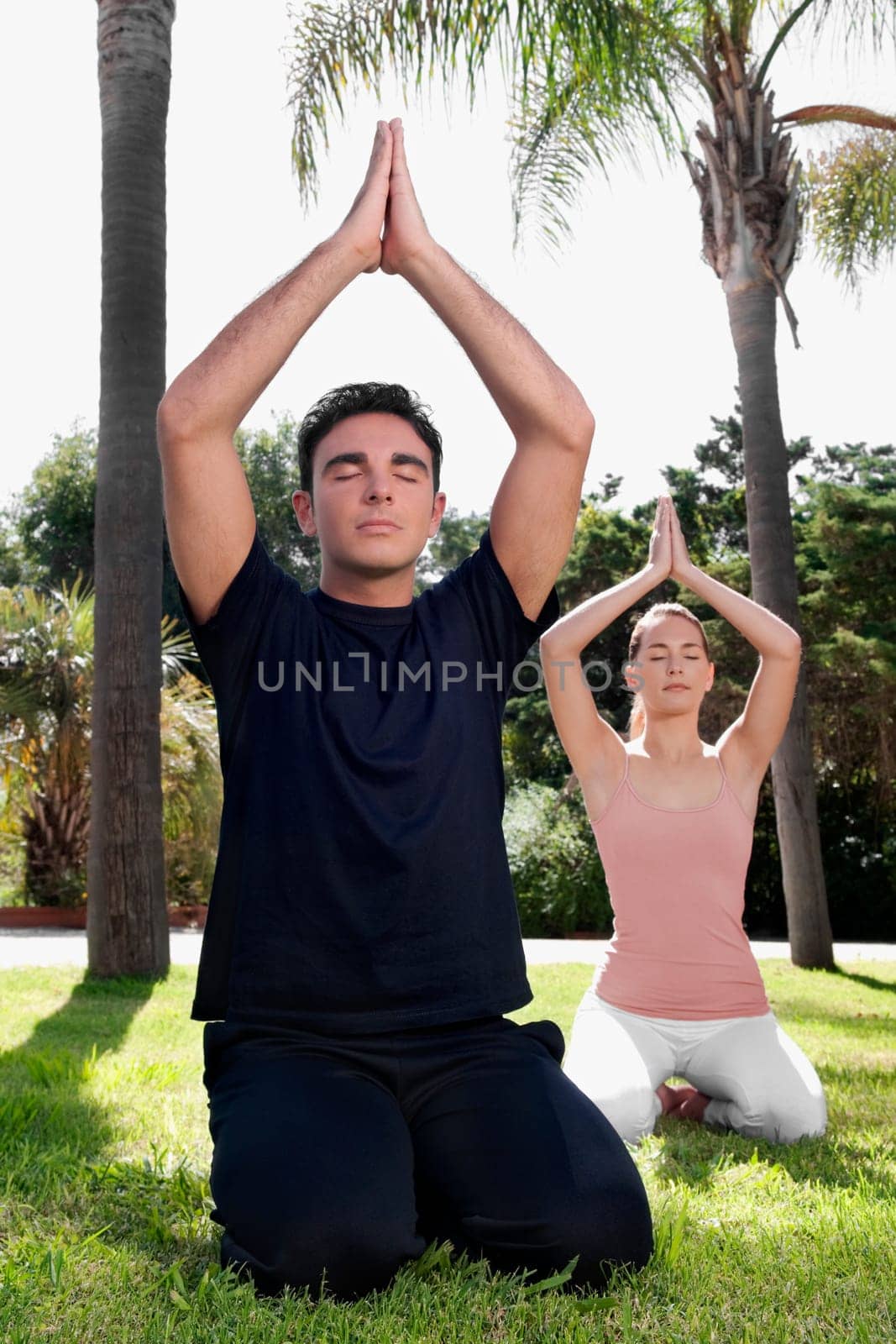 Couple practicing yoga in a park