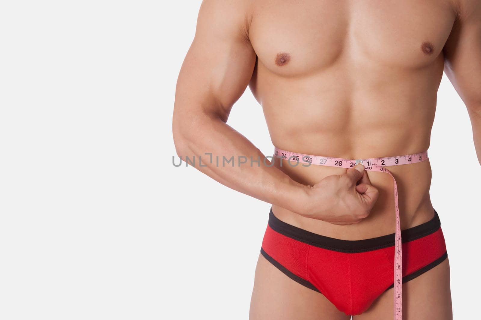 Man measuring his waist with a tape measure
