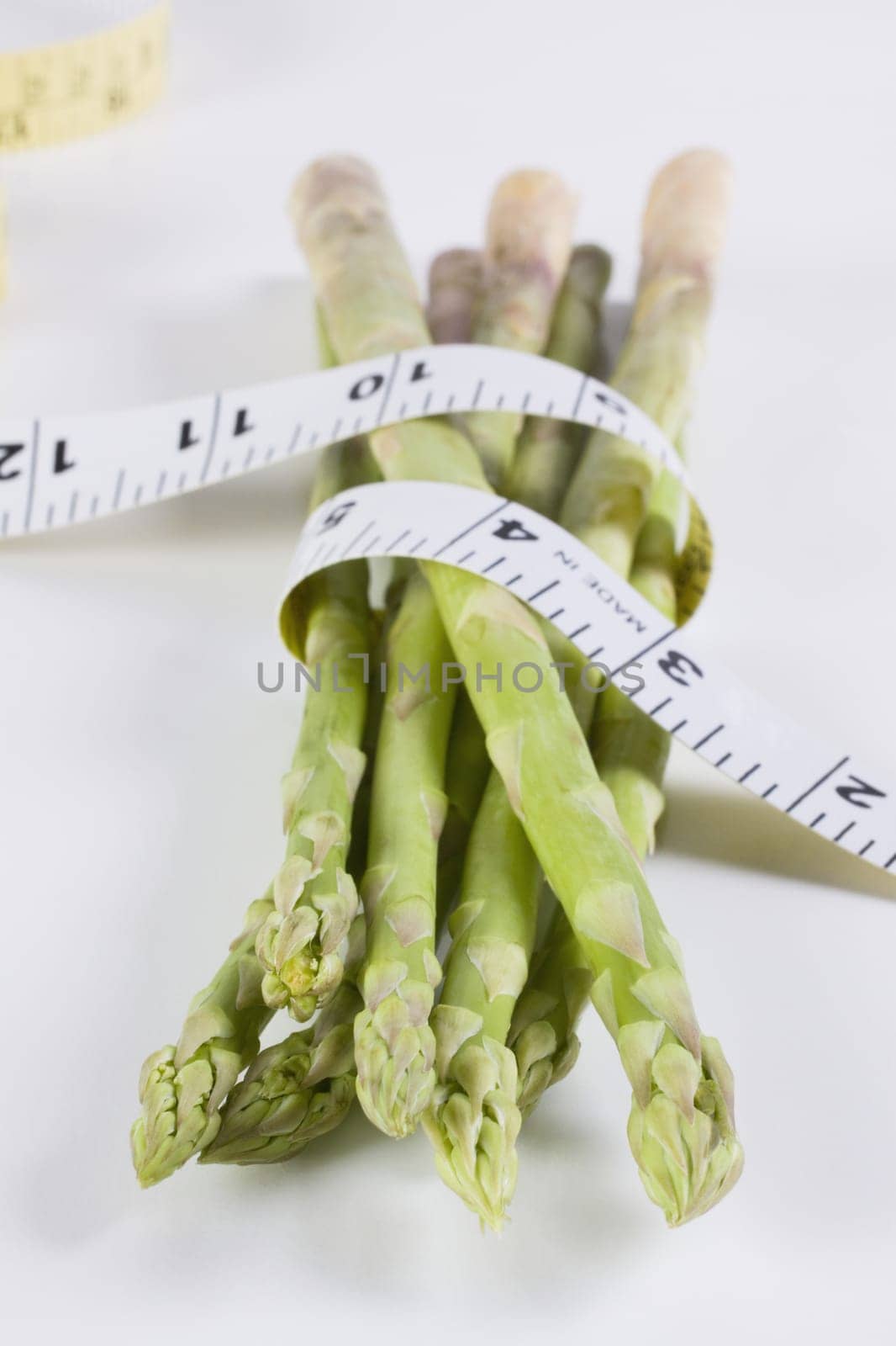 Close_up of a tape measure wrapped around asparagus stalks