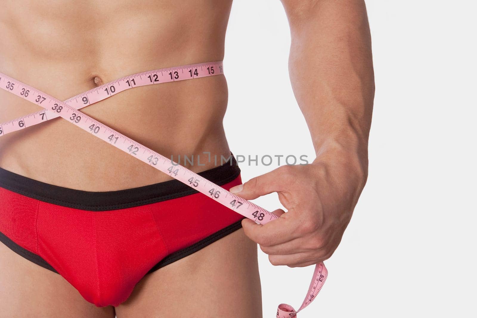 Man measuring his waist with a tape measure