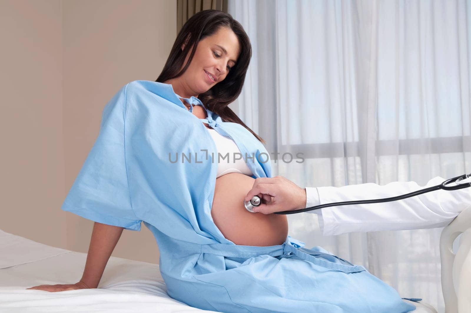 Doctor examining a pregnant woman with a stethoscope