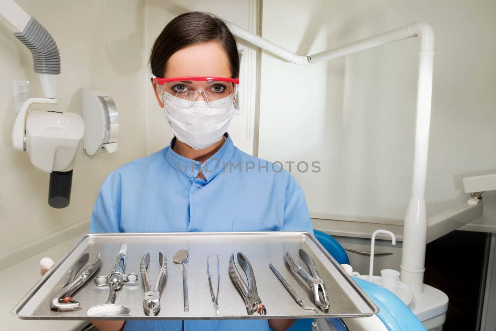 Portrait of a female dentist holding a tray of dental equipments
