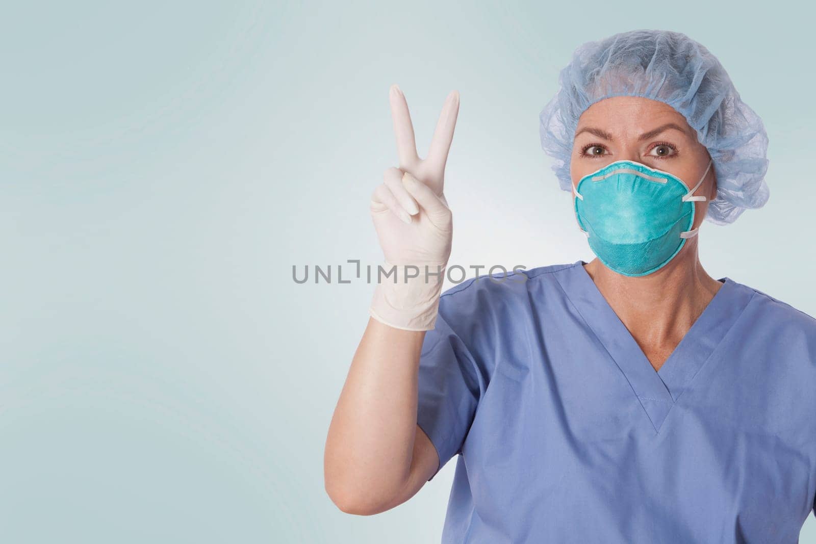 Female surgeon showing victory sign