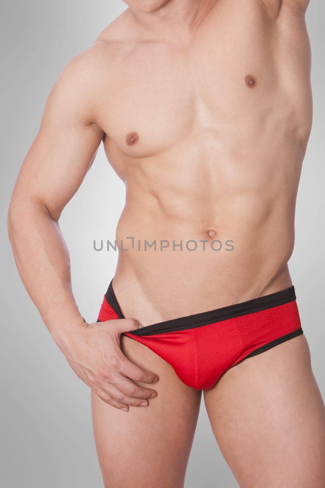 Mid section view of a man pulling down his underwear