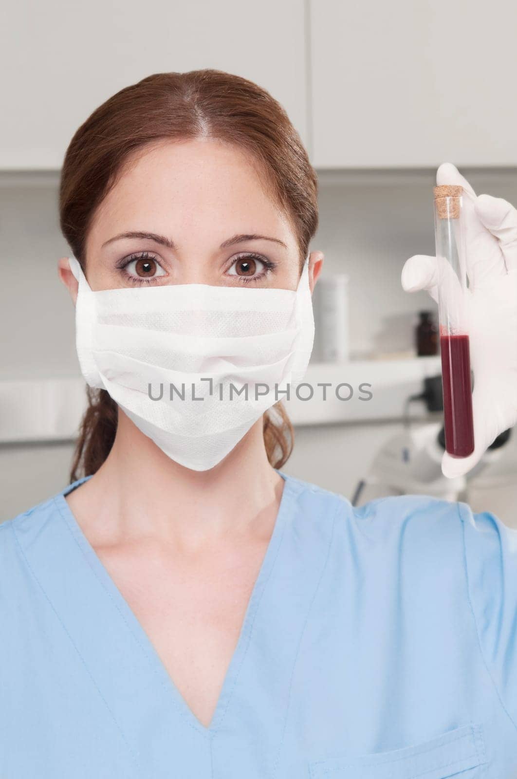 Female lab technician analyzing a blood sample in a test tube