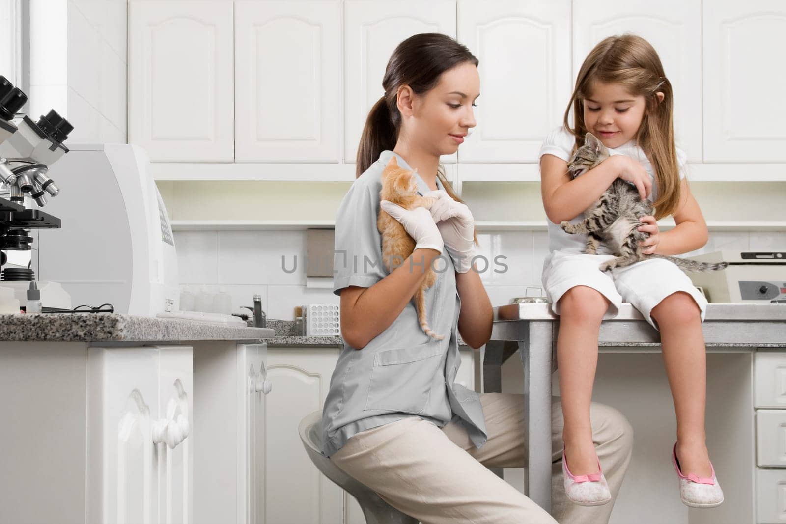 Female vet with a girl carrying cats