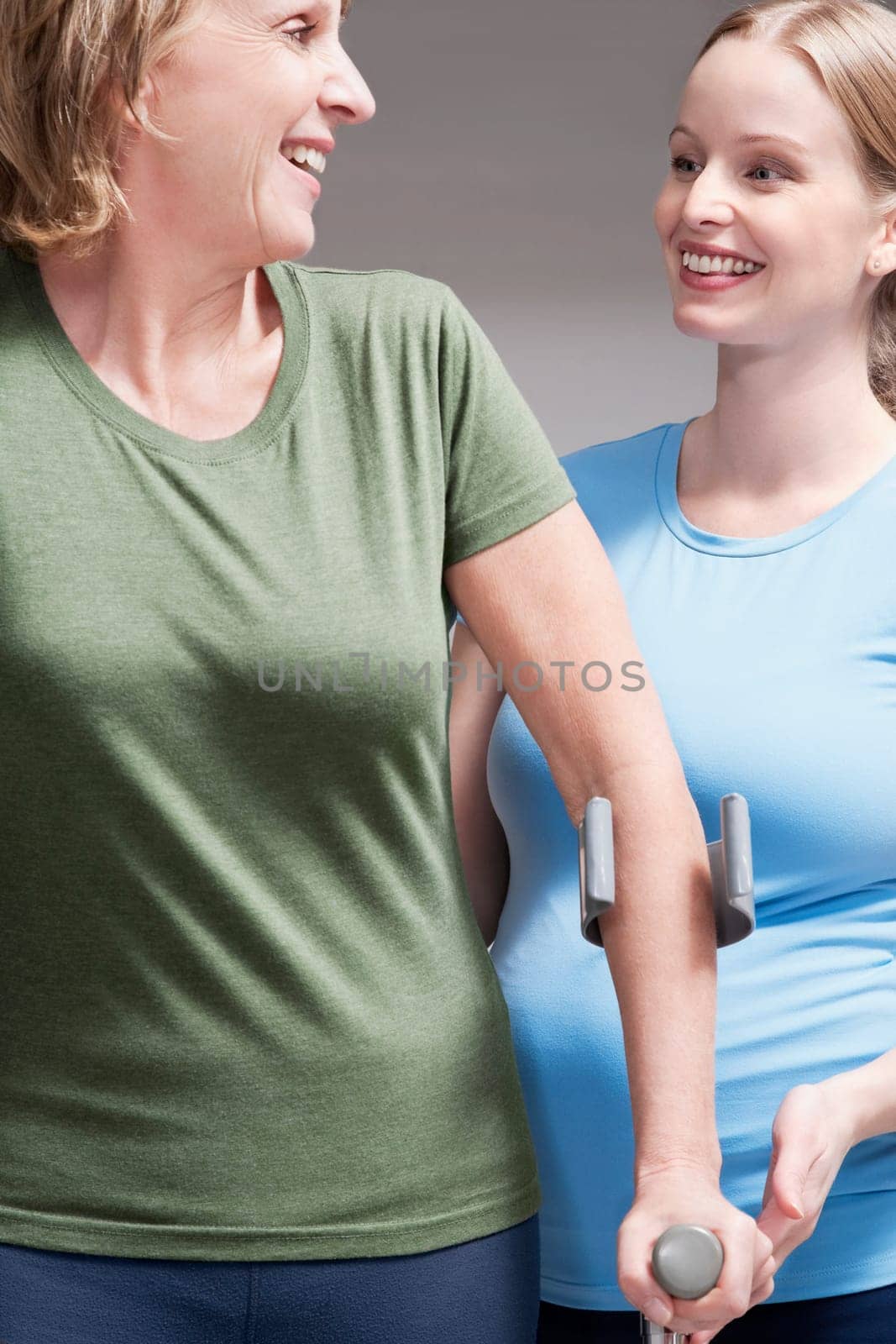 Physiotherapist assisting a patient in walking with crutches