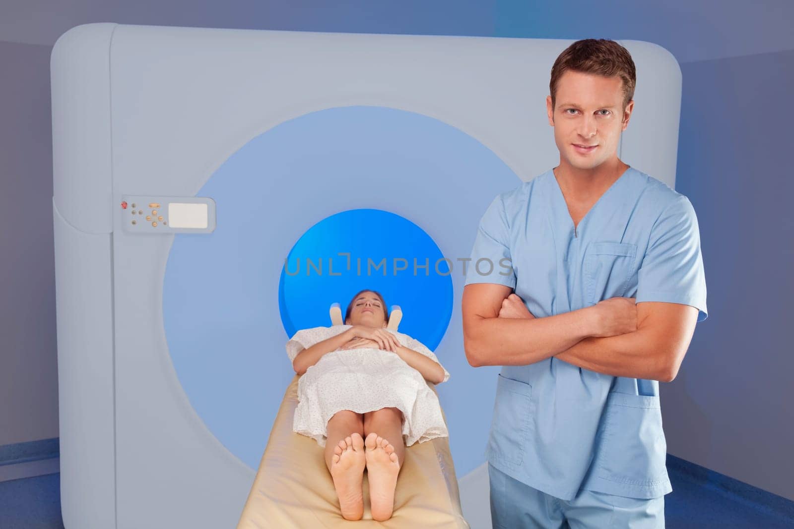 Healthcare worker standing beside a patient undergoing an MRI scan