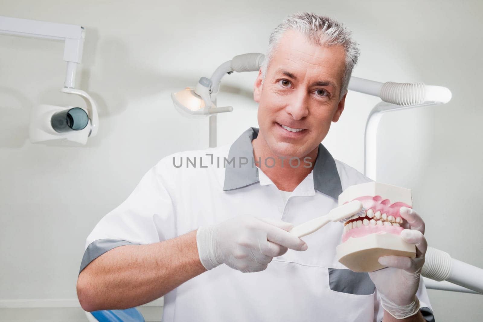 Dentist using a toothbrush on dentures