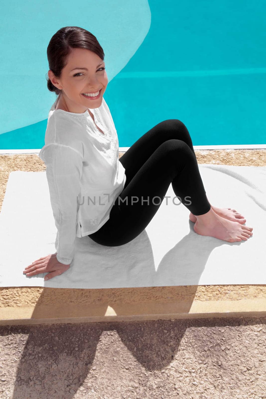 Woman exercising at the poolside and smiling