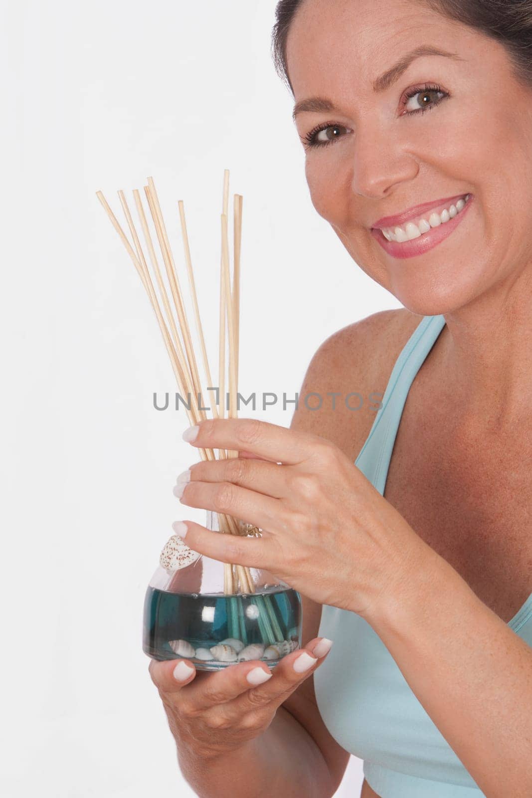 Woman holding an aromatherapy oil bottle with incenses