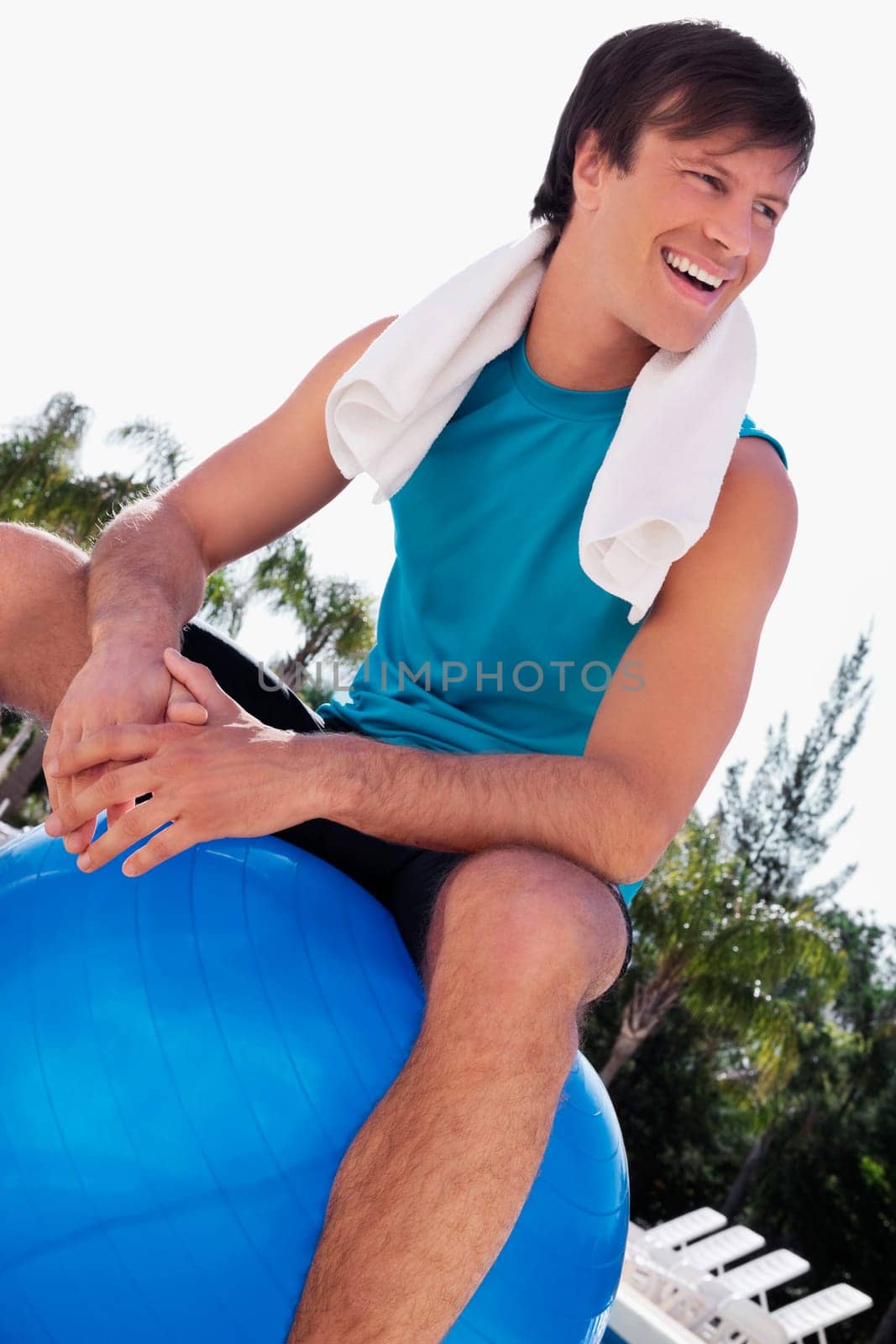 Man sitting on a fitness ball and laughing