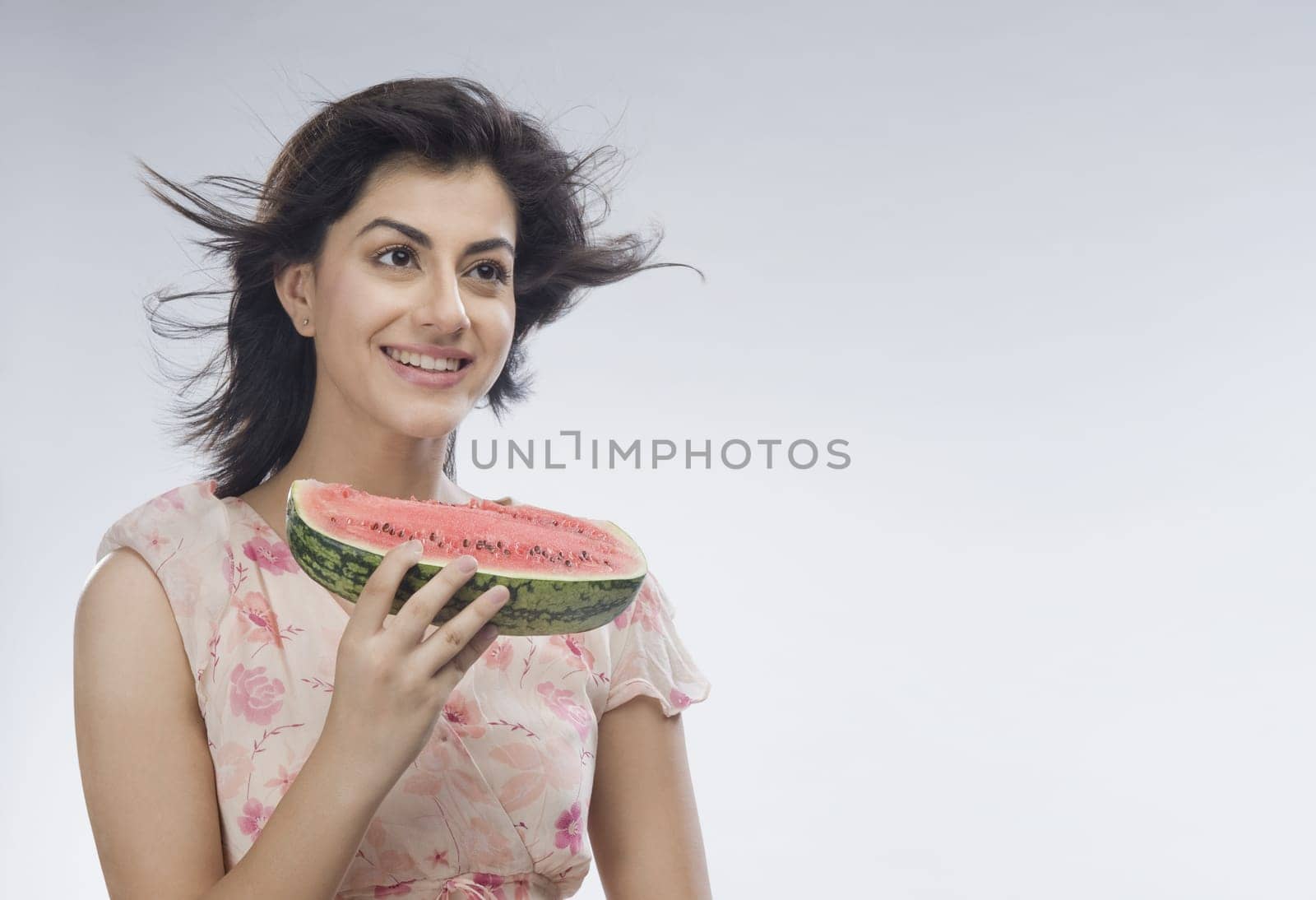 Woman eating watermelon and day dreaming