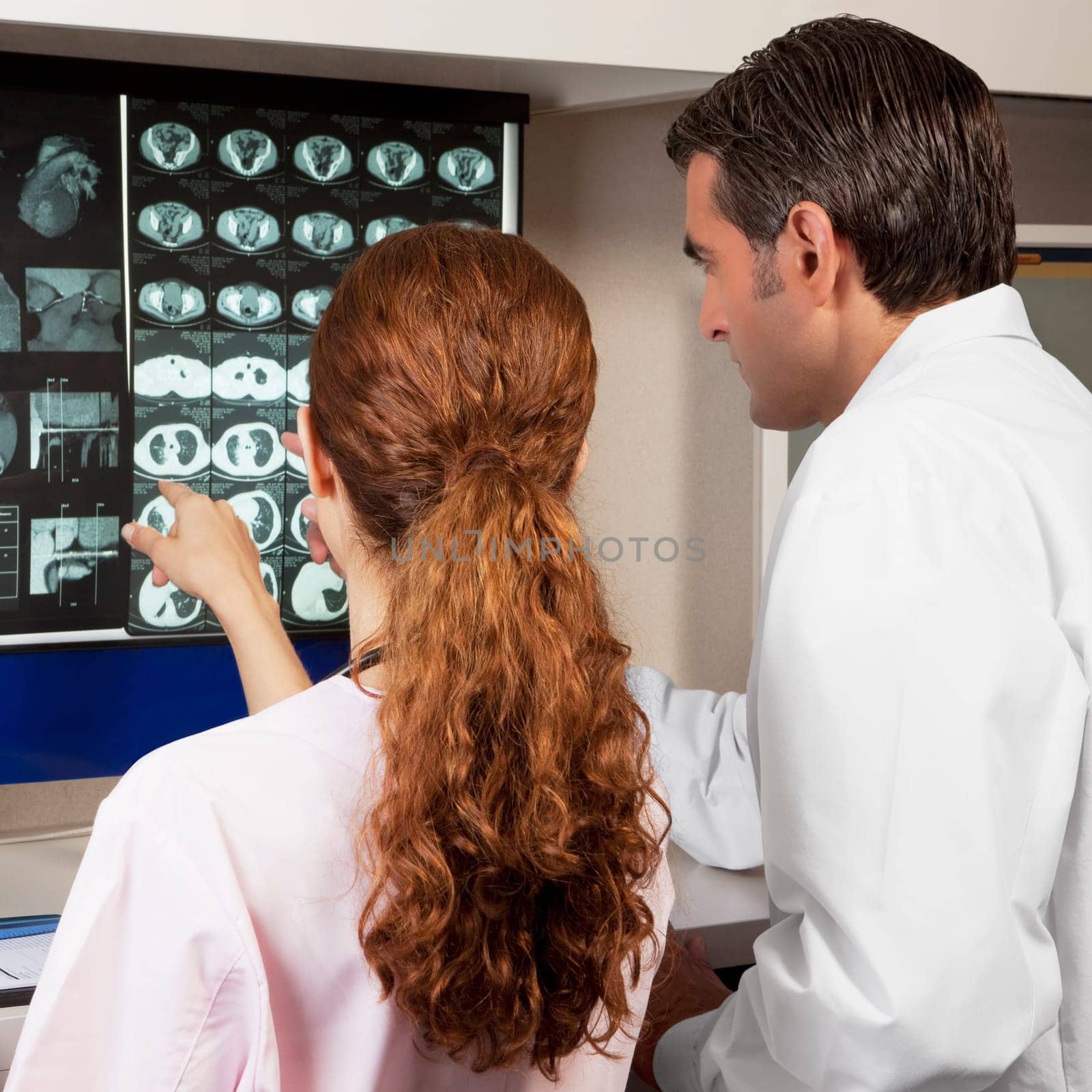 Two doctors examining MRI report