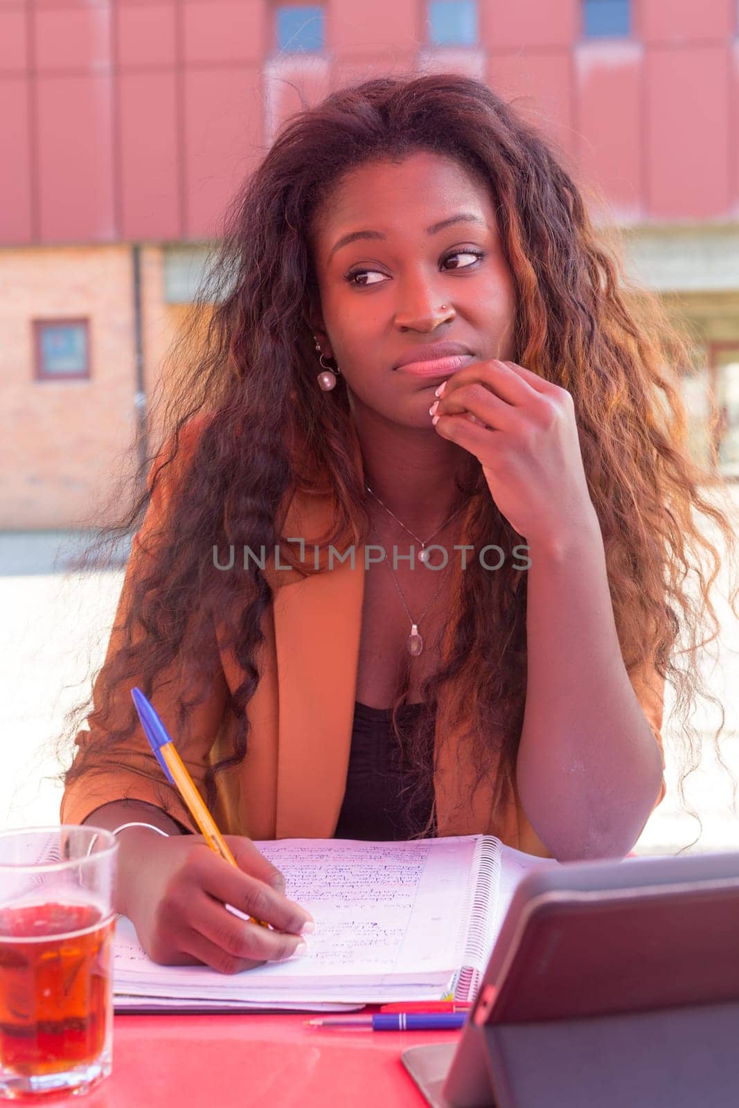 Young african student preparing her exams at a local cafeteria
