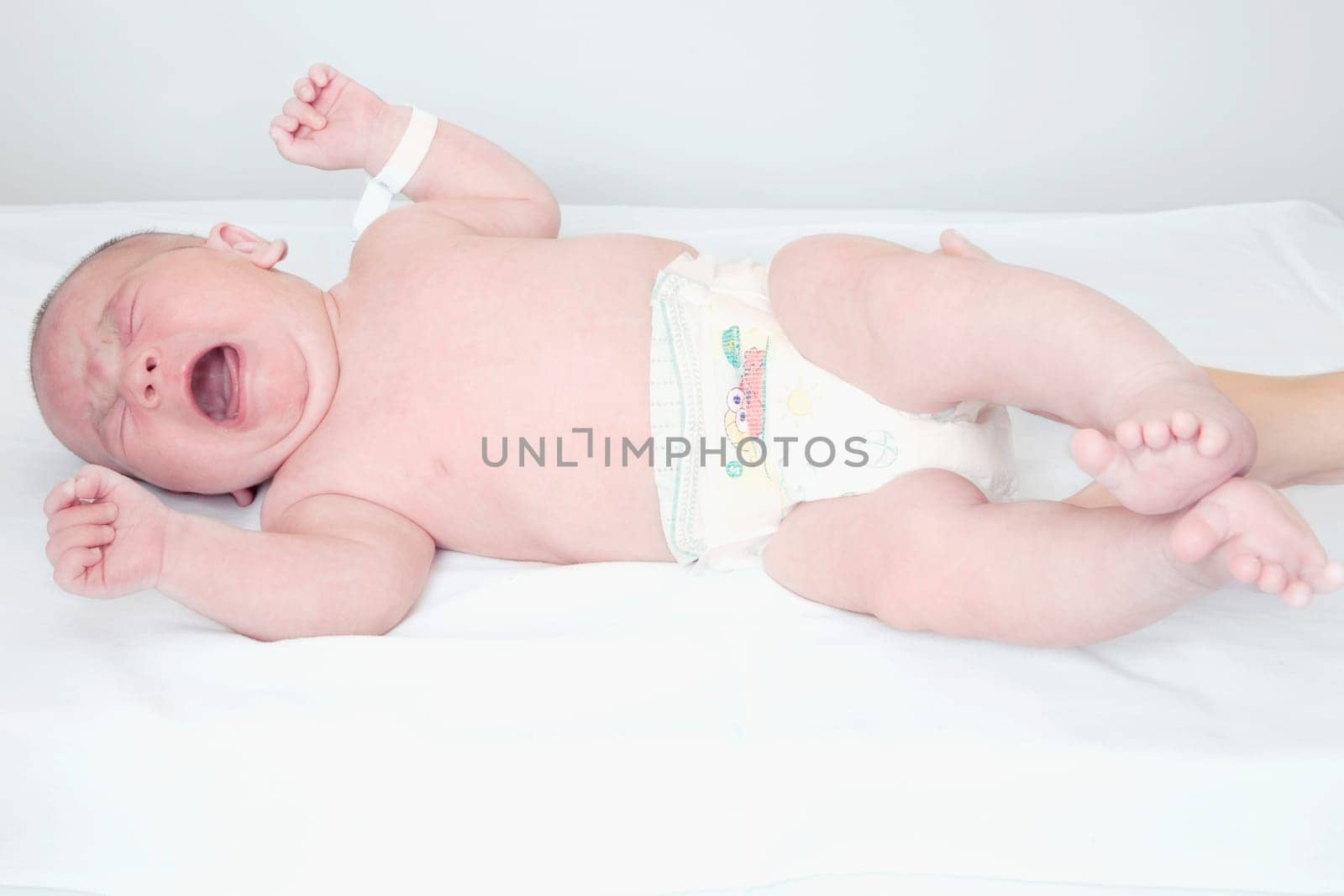 Newborn baby crying on the bed