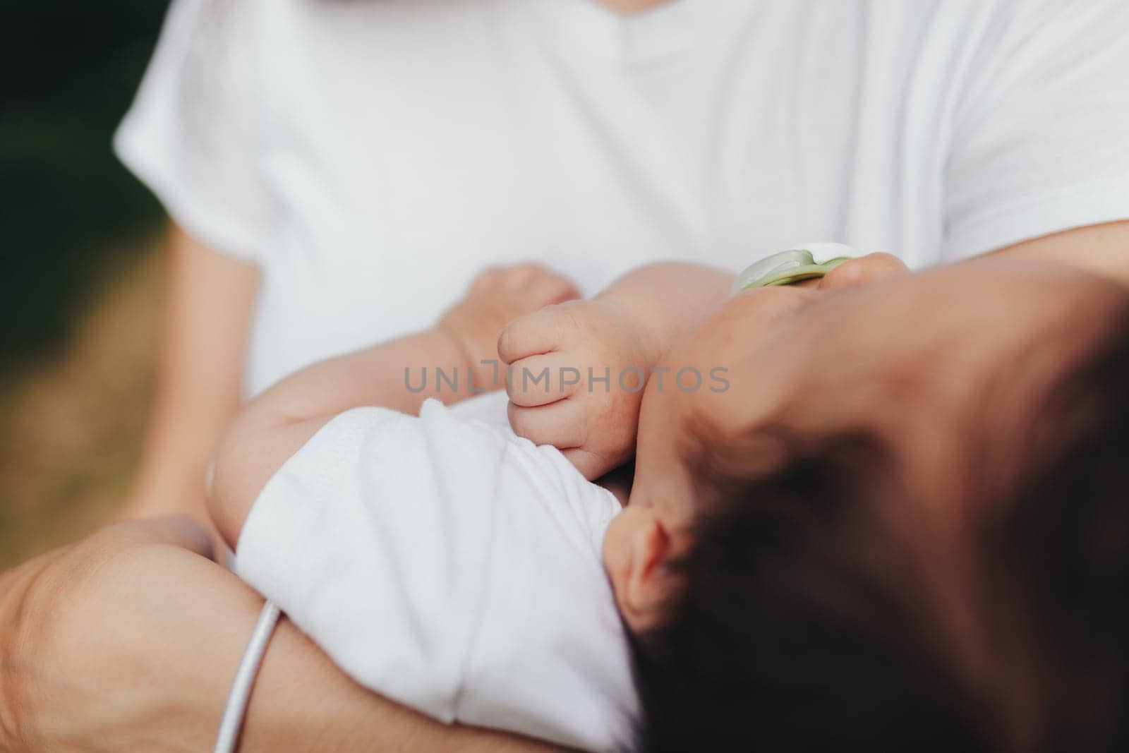 Little baby's hands, mother with baby, care of baby, mother carrying baby. High quality photo
