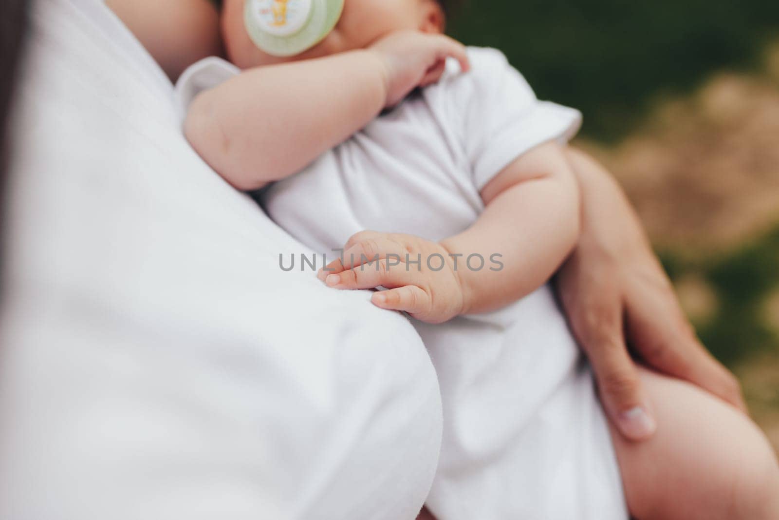 Little baby's hands, mother with baby, care of baby, mother carrying baby. High quality photo