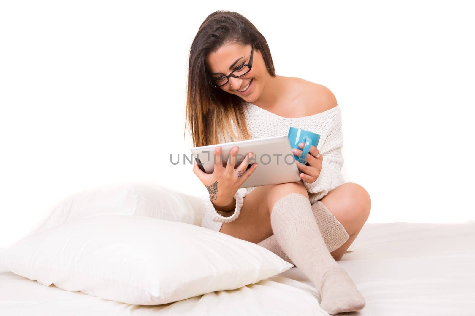 Young beautiful woman in bed, working or relaxing with her computer