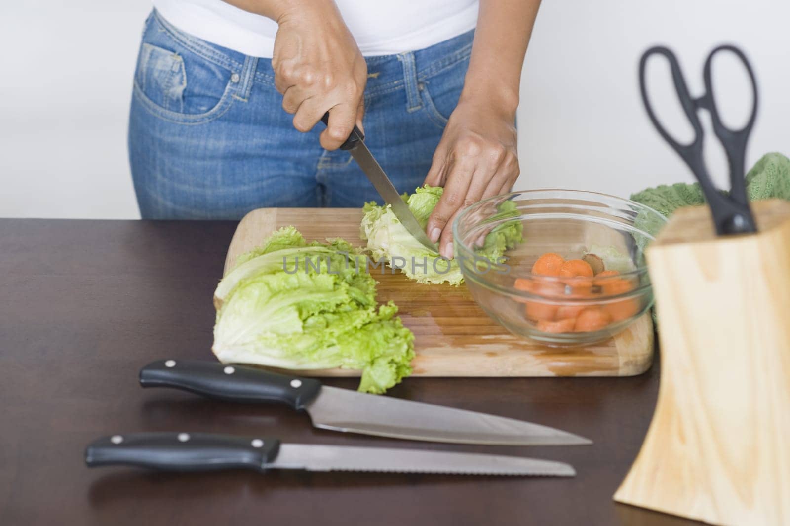 Mid section view of a woman chopping lettuce