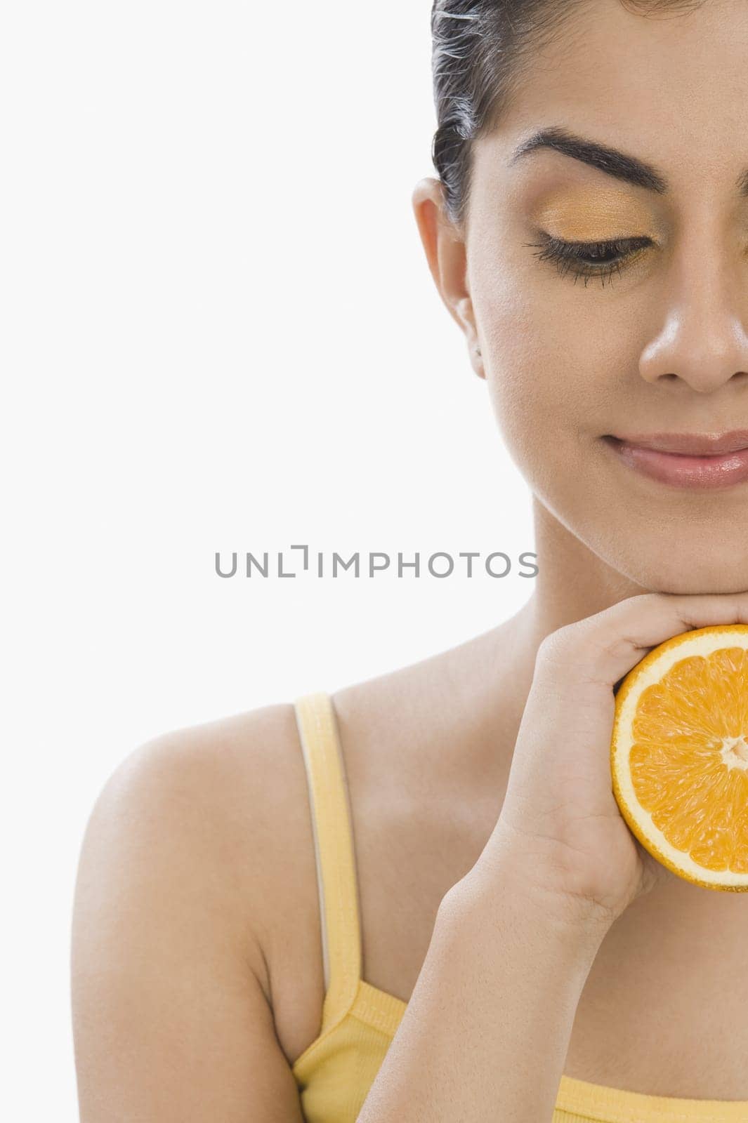 Close_up of a woman holding a half of orange
