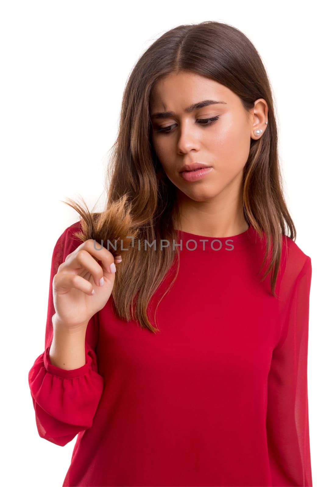 Young woman looking at her hair isolated over white