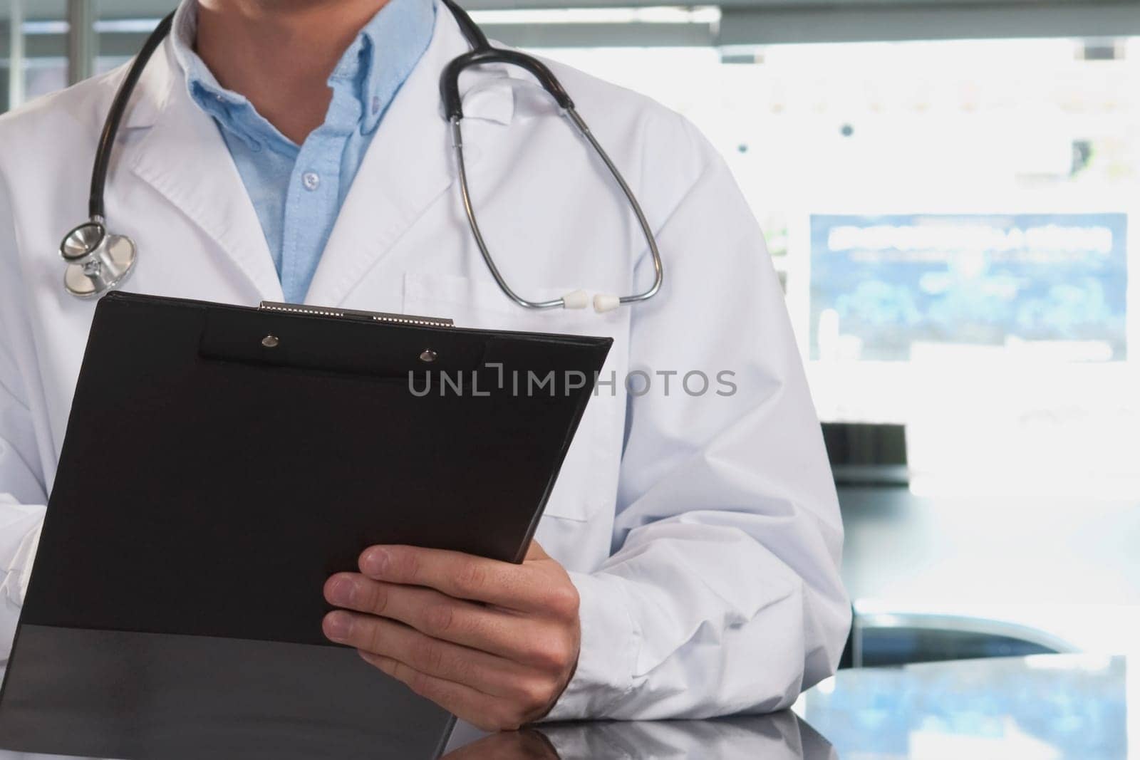 Mid section view of a doctor holding a clipboard