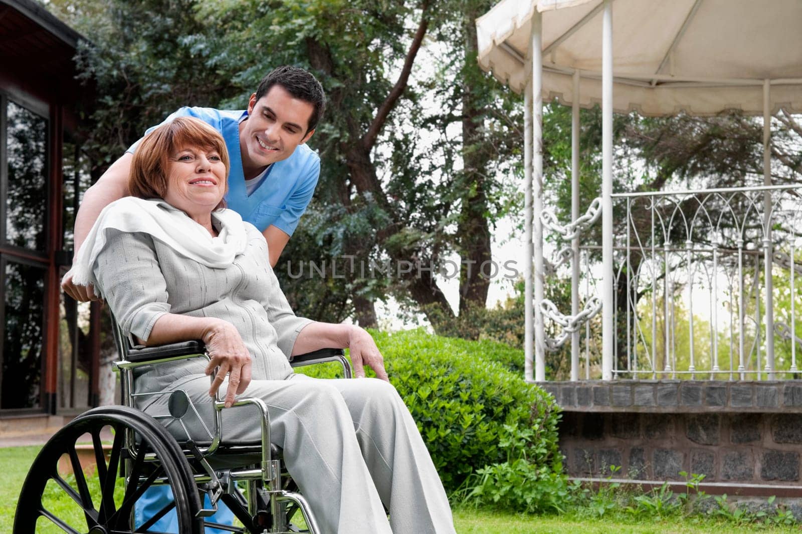 Healthcare worker pushing a woman sitting in a wheelchair