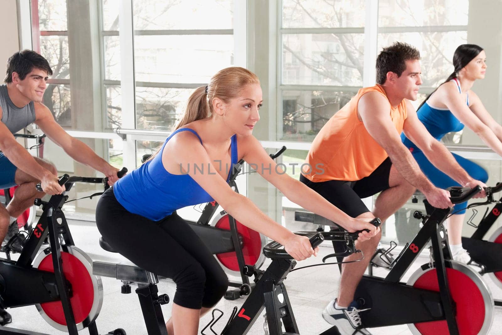 Men and women working out on exercise bikes in a gym