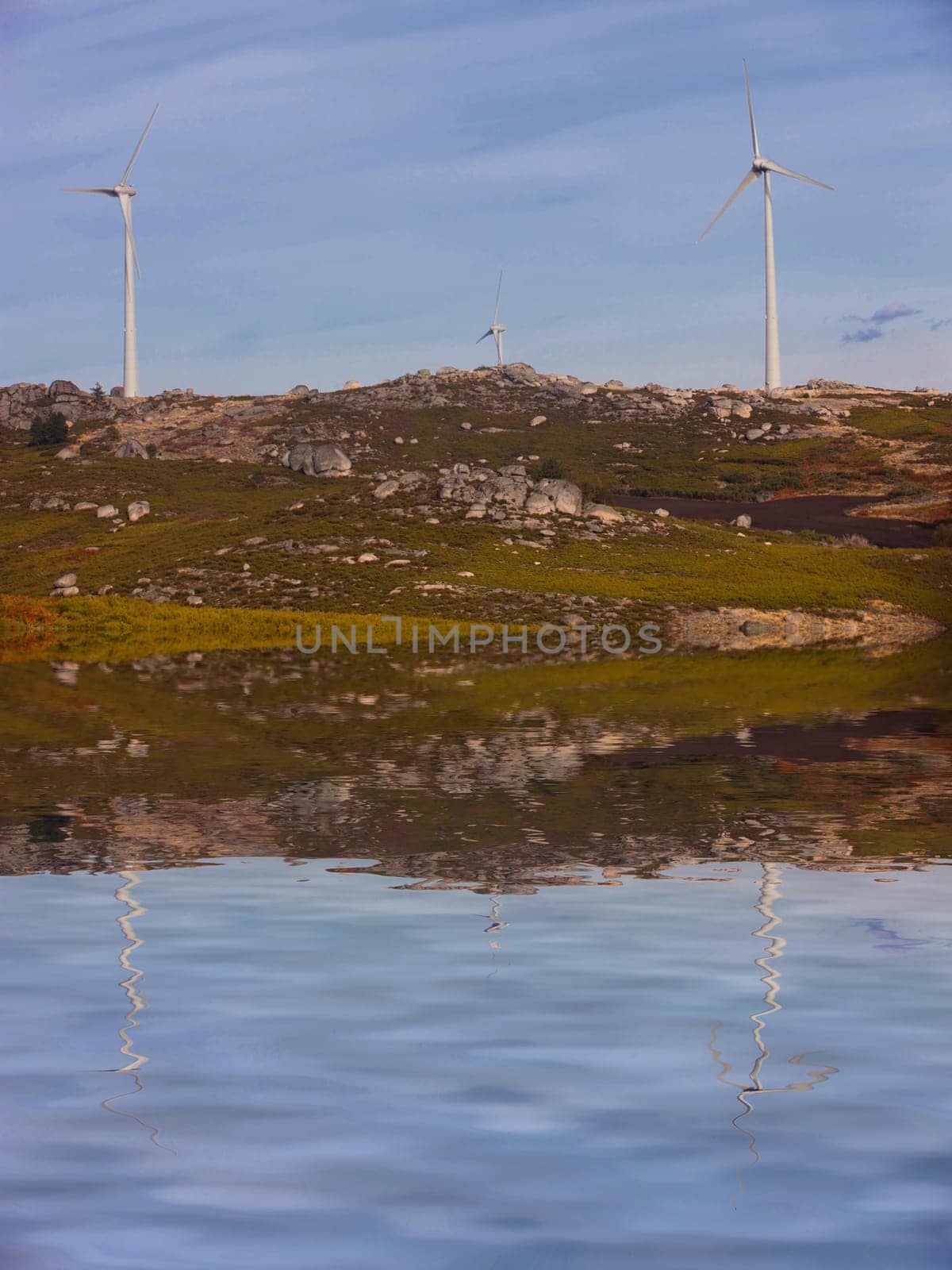 White wind turbines at the top of the mountain