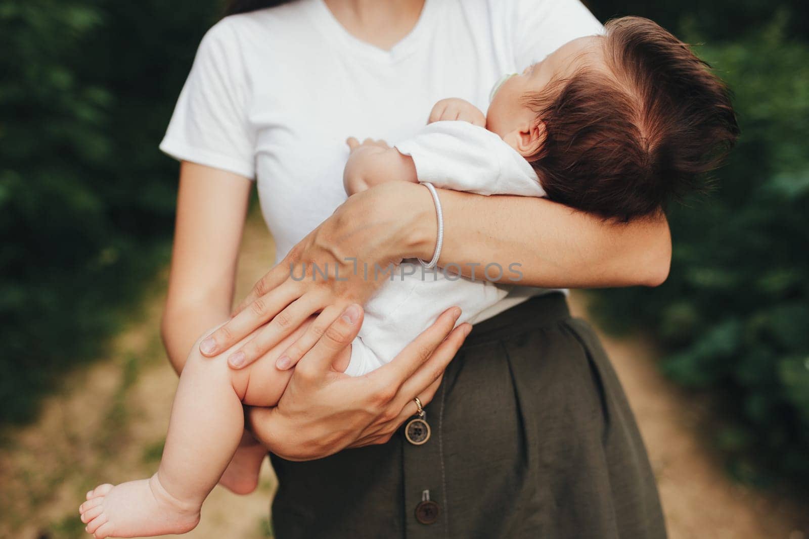Little baby's hands, mother with baby, care of baby, mother carrying baby. High quality photo